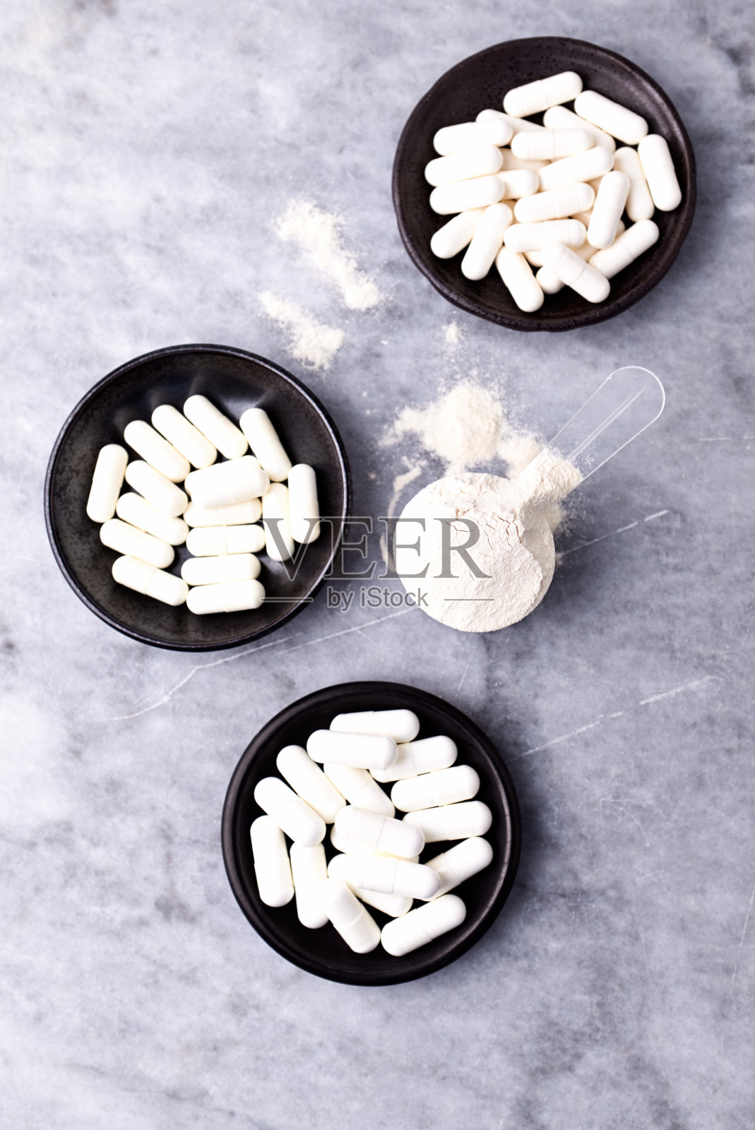 乳清蛋白,水解膠原I型,l -脯氨酸和l -賴氨酸膠囊勺。補(bǔ)充膠原蛋白的生產(chǎn)。明亮的石頭背景。直接上圖。副本的空間。